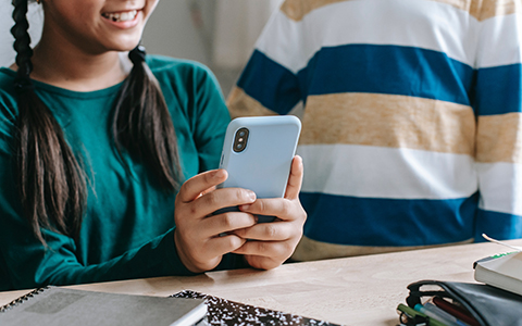 Photo of two children watching a video on a smartphone.