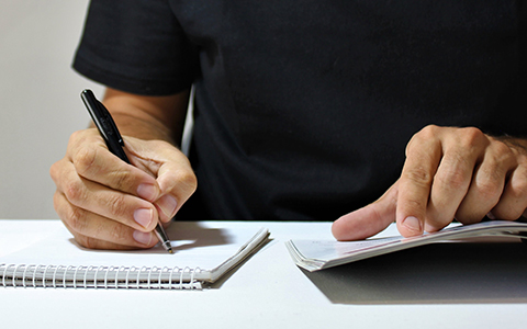 Photo of a man writing.